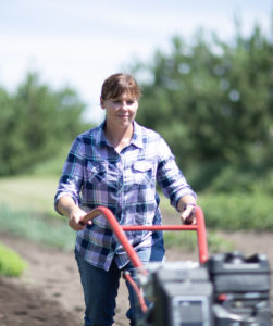 Farmer using till on her field.